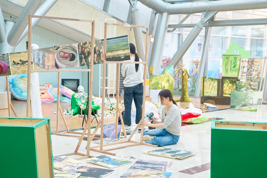 전동 드라이버로 작품을 설치하는 여학생 2명