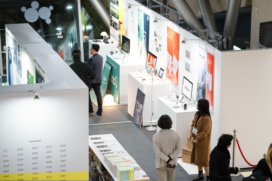 전시 부스 사이를 걷는 관람객 4명