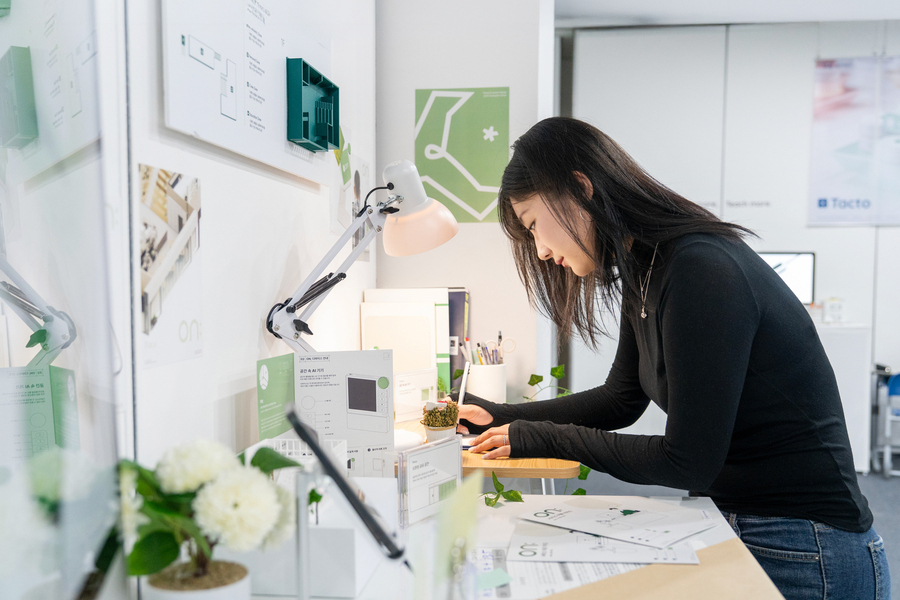 전시장에서 글을 쓰는 여학생